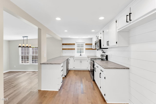 105 N 11th St, Erwin, NC 28339 - kitchen with open shelves, white cabinetry, a sink, stainless steel appliances, and light wood-style flooring
