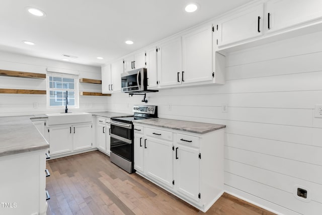 105 N 11th St, Erwin, NC 28339 - kitchen with a sink, open shelves, stainless steel appliances, and white cabinetry