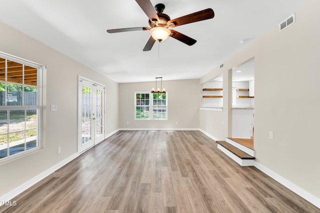105 N 11th St, Erwin, NC 28339 - unfurnished living room featuring baseboards, ceiling fan with notable chandelier, and light wood finished floors