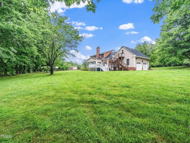 12823 Summerwind Trl, Rougemont, NC 27572 - view of grassy yard with stairway, a garage, and a deck