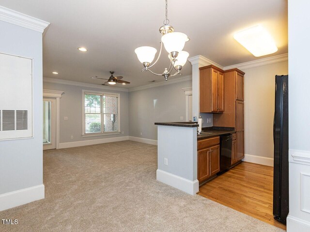 kitchen featuring crown molding, dark countertops, brown cabinets, ceiling fan with notable chandelier, and black appliances