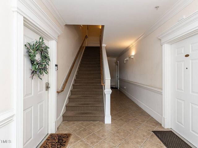 stairs featuring crown molding and tile patterned floors