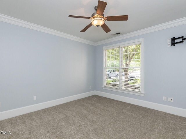 carpeted spare room with baseboards, ornamental molding, ceiling fan, and visible vents