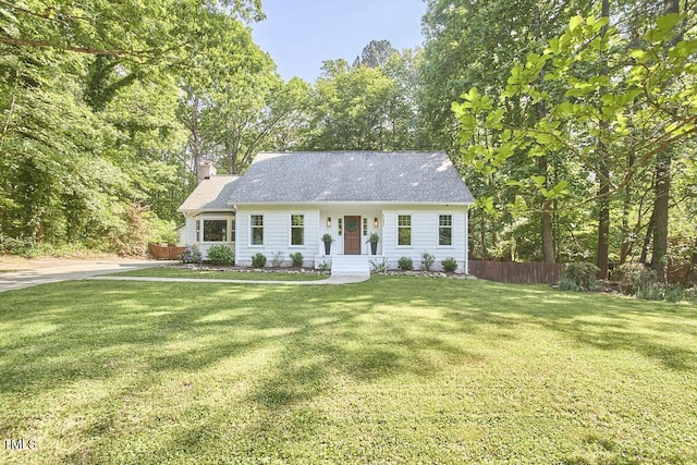 view of front of home with fence, a chimney, and a front yard
