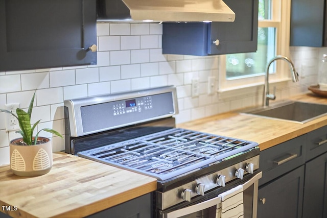 kitchen with a sink, stainless steel gas range oven, wooden counters, wall chimney exhaust hood, and backsplash