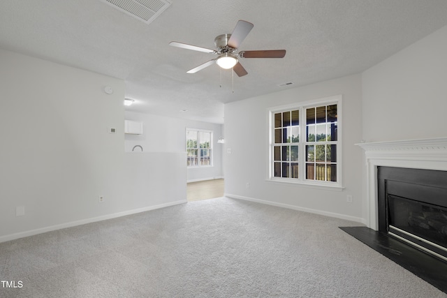 unfurnished living room featuring a glass covered fireplace, baseboards, a ceiling fan, and visible vents