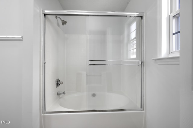 bathroom featuring bath / shower combo with glass door