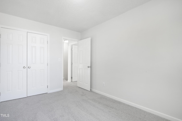 unfurnished bedroom featuring baseboards, carpet, and a closet
