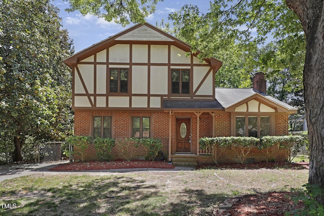 101 Atchison St, Garner, NC 27529 - tudor home with brick siding, fence, a chimney, and a shingled roof