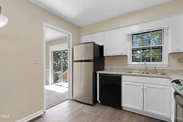 101 Atchison St, Garner, NC 27529 - kitchen featuring stainless steel appliances, a wealth of natural light, a sink, and light wood finished floors