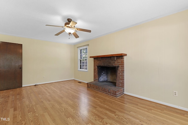 101 Atchison St, Garner, NC 27529 - unfurnished living room featuring light wood-style floors, ceiling fan, a fireplace, and crown molding