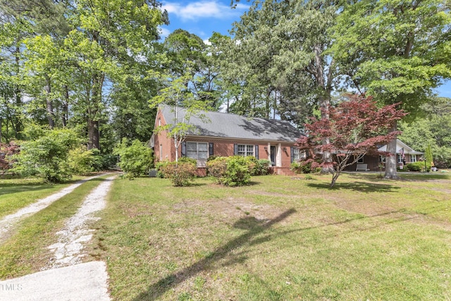 view of front facade with dirt driveway and a front lawn