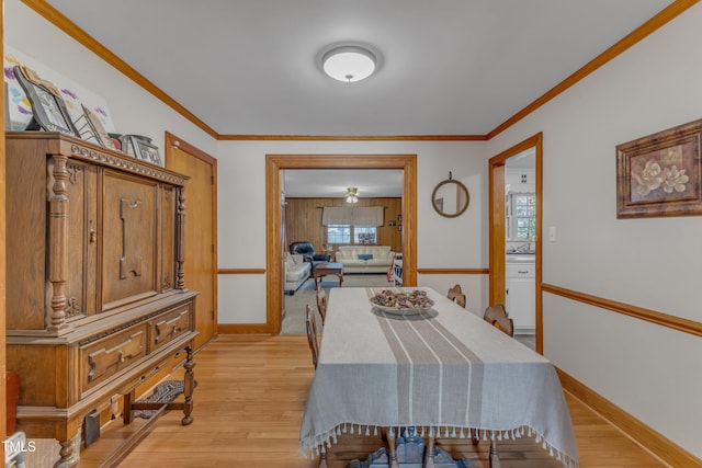 dining room featuring crown molding, baseboards, and light wood-type flooring