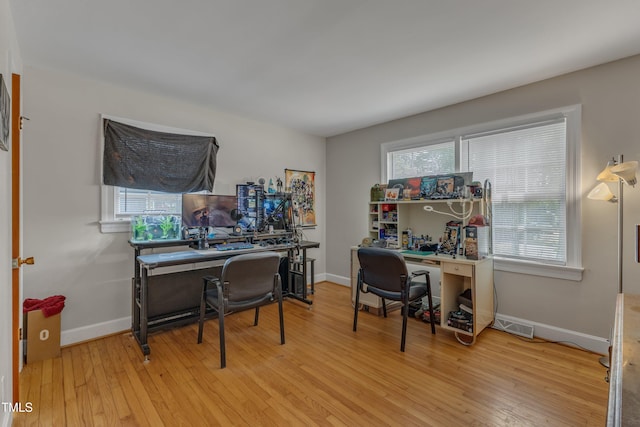 office with baseboards, light wood finished floors, and visible vents