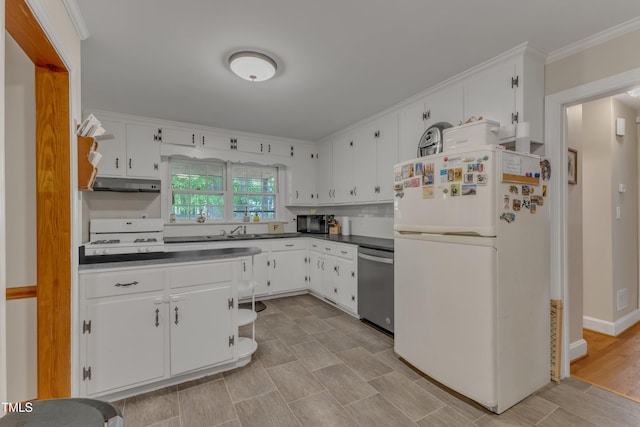 kitchen featuring dark countertops, freestanding refrigerator, white cabinetry, stainless steel dishwasher, and under cabinet range hood
