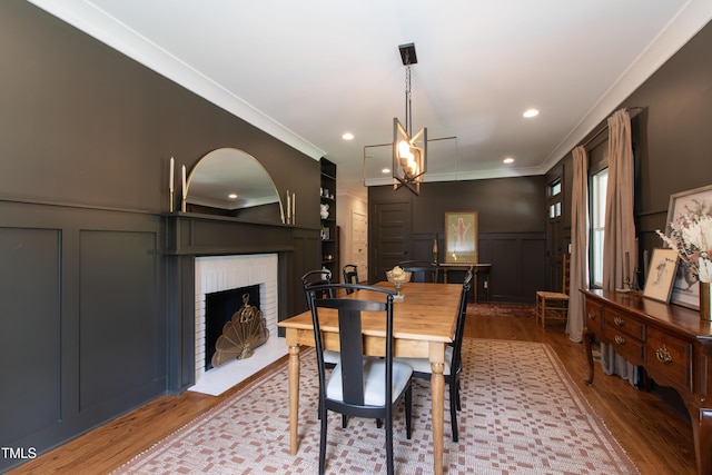 2517 Medway Dr, Raleigh, NC 27608 - dining room featuring crown molding, an inviting chandelier, a decorative wall, and wood finished floors