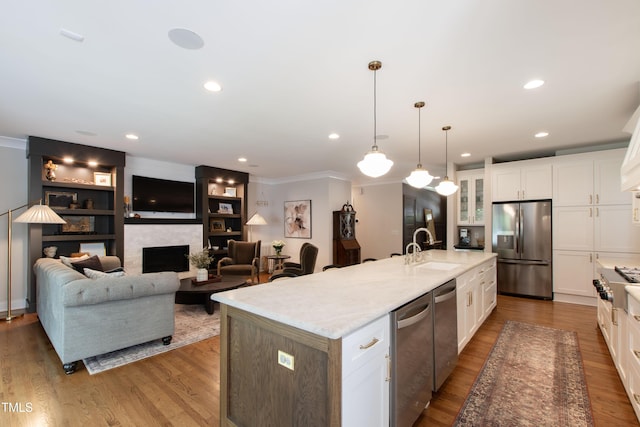 2517 Medway Dr, Raleigh, NC 27608 - kitchen featuring a sink, white cabinets, appliances with stainless steel finishes, and a center island with sink