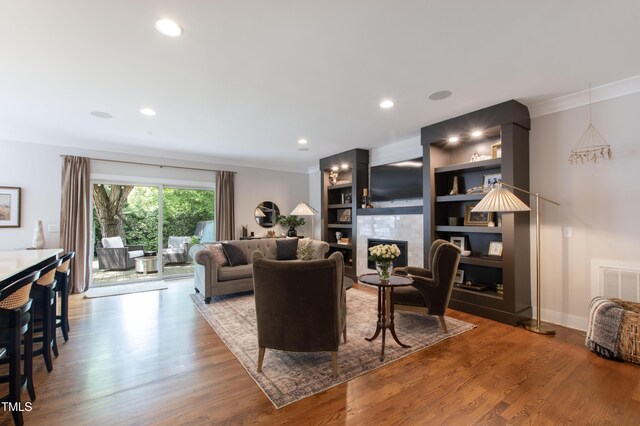 2517 Medway Dr, Raleigh, NC 27608 - living room featuring recessed lighting, wood finished floors, a tile fireplace, visible vents, and ornamental molding
