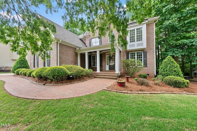view of front of house featuring brick siding and a front lawn