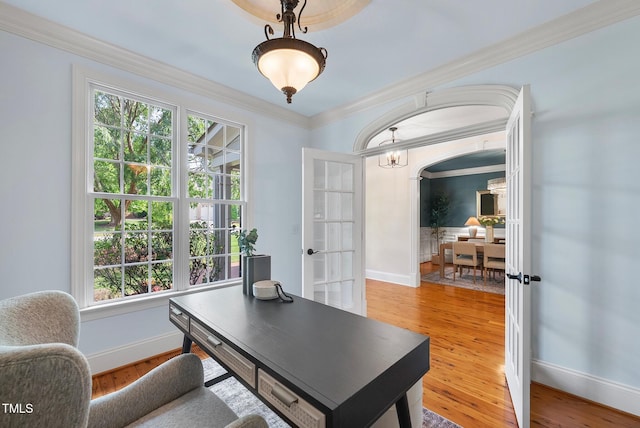 office space with french doors, healthy amount of natural light, baseboards, ornamental molding, and light wood-type flooring