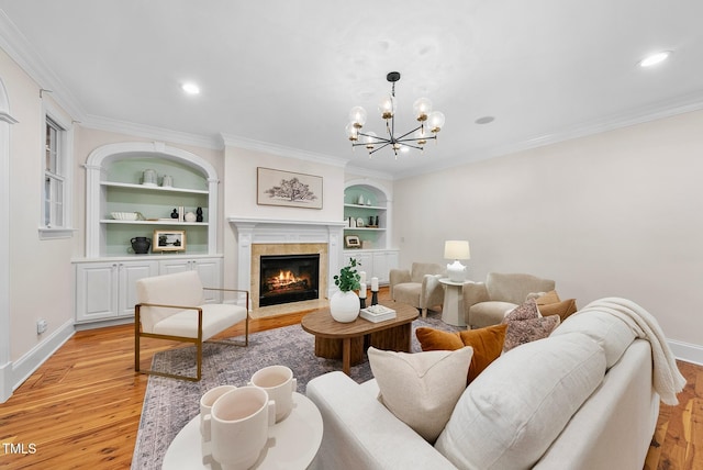 living area with light wood finished floors, baseboards, built in features, a chandelier, and crown molding