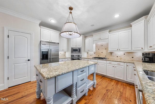 kitchen featuring built in appliances, white cabinetry, tasteful backsplash, crown molding, and light wood-type flooring