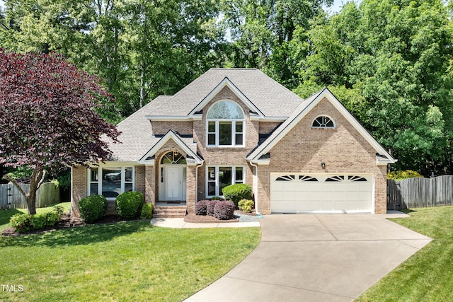 craftsman inspired home with brick siding, a front lawn, fence, and concrete driveway