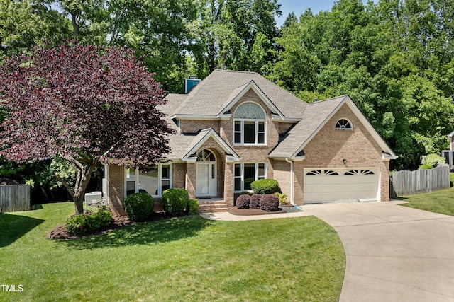 craftsman house with brick siding, fence, driveway, and a front yard