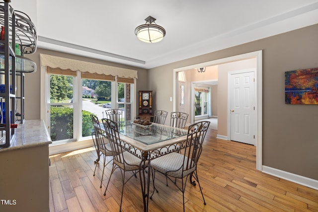 dining room featuring baseboards and light wood-type flooring