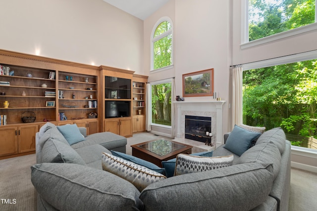 living room featuring high vaulted ceiling, light carpet, and a fireplace