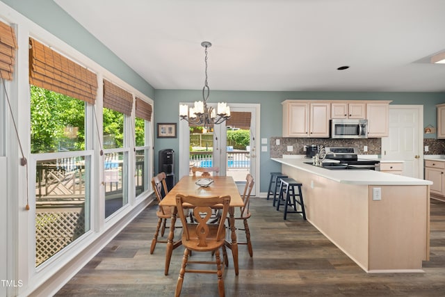 dining area featuring an inviting chandelier, baseboards, and dark wood-style flooring