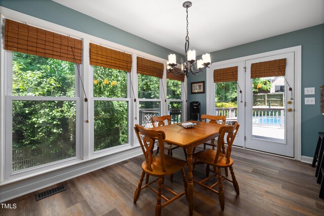 dining space with visible vents, dark wood finished floors, and a notable chandelier