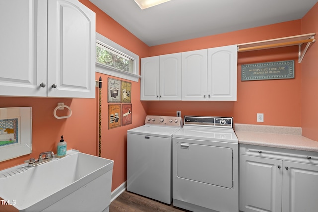 laundry area featuring dark wood-style flooring, baseboards, washing machine and clothes dryer, a sink, and cabinet space