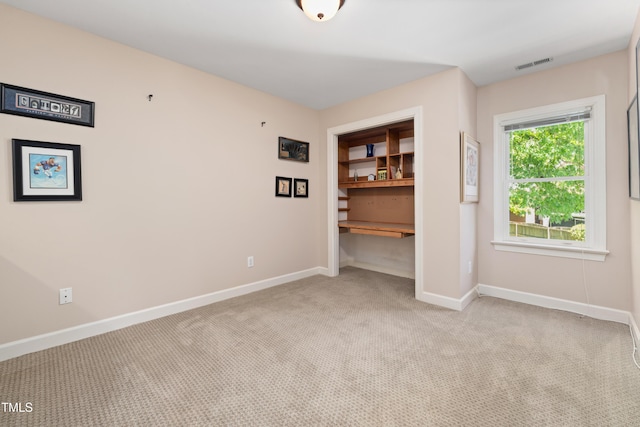 spare room with visible vents, carpet, and baseboards