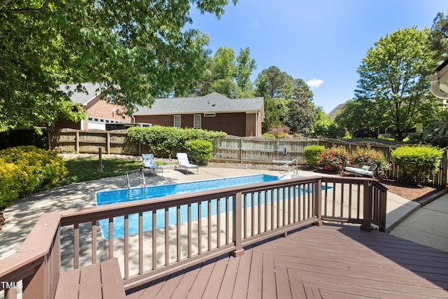 view of swimming pool with a fenced backyard, a fenced in pool, a patio area, and a wooden deck