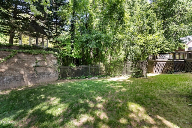 view of yard featuring fence and a deck