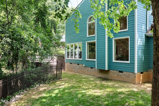 view of property exterior featuring a yard, crawl space, and fence