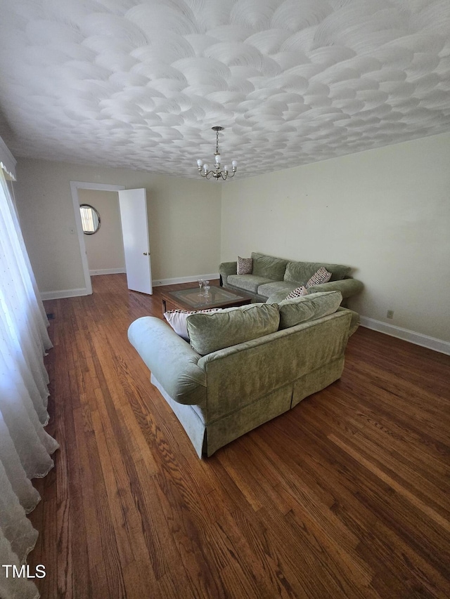 living area featuring a chandelier, baseboards, and wood finished floors