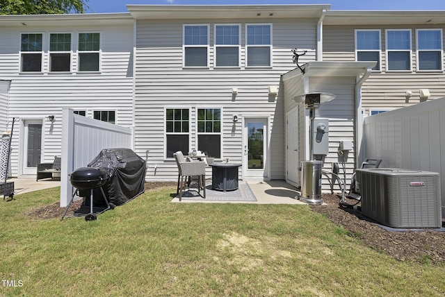 back of property with central air condition unit, fence, a patio, and a lawn