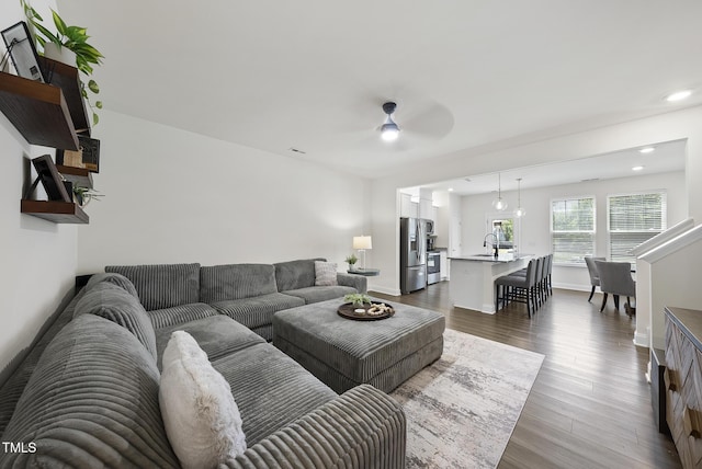 living area featuring recessed lighting, a ceiling fan, dark wood-style flooring, and baseboards