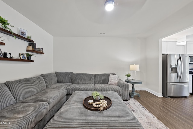 living room featuring baseboards, wood finished floors, and visible vents