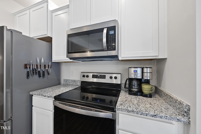 kitchen featuring white cabinetry, light stone countertops, and stainless steel appliances