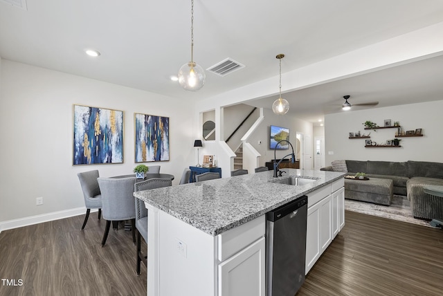 kitchen with white cabinets, a sink, open floor plan, stainless steel dishwasher, and visible vents