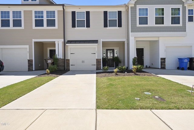 view of front of property with an attached garage, a front lawn, driveway, and stone siding