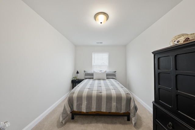bedroom with baseboards, visible vents, and light carpet