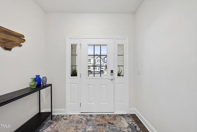 entryway featuring baseboards and dark wood finished floors