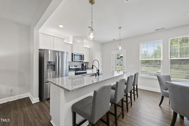 kitchen featuring visible vents, appliances with stainless steel finishes, a sink, baseboards, and dark wood-style floors