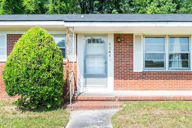 entrance to property featuring brick siding
