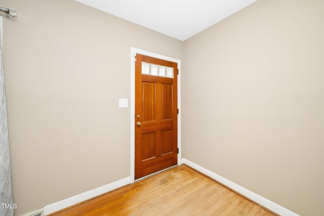 foyer with baseboards and light wood-style flooring