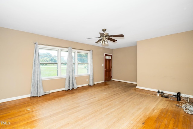 empty room featuring ceiling fan, baseboards, and light wood-style flooring